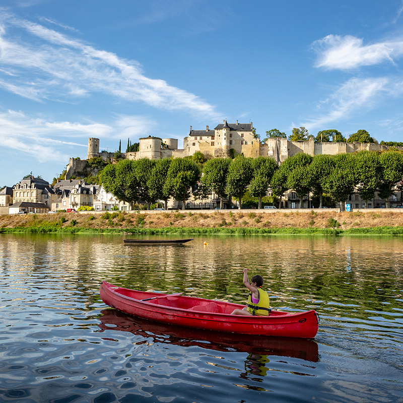jeune femme en canoë sur la Loire devant la forteresse royale de chinon